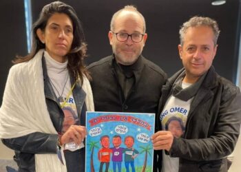 האמן זאב אנגלמאיר, מעניק את הגלויה היומית להוריו של עומר שם טוב. צילום מתוך עמוד הפייסבוק של האמן