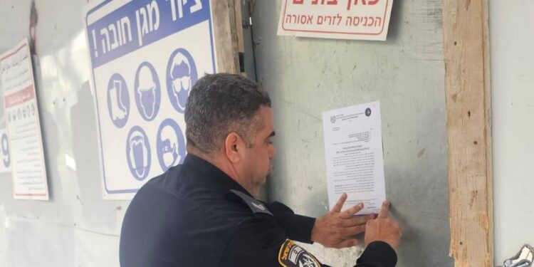 תיעוד הדבקת הצו באתר הבניה. צילום דוברות המשטרה.