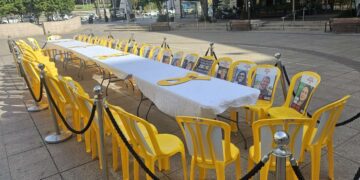 ברחבת בניין העירייה: שולחן חג עם כיסאות צהובים ריקים ועליהם תמונותיהם של 48 החטופים.צילום דוברות העירייה