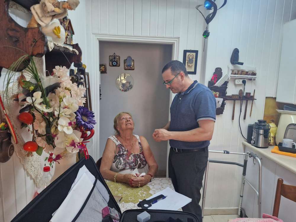 ד״ר אלדד אדלר, רופא עיניים המתנדב בעמותה עם פאניקה פולק, בת 88, שקיבלה את הבדיקה. צילום באדיבות העמותה