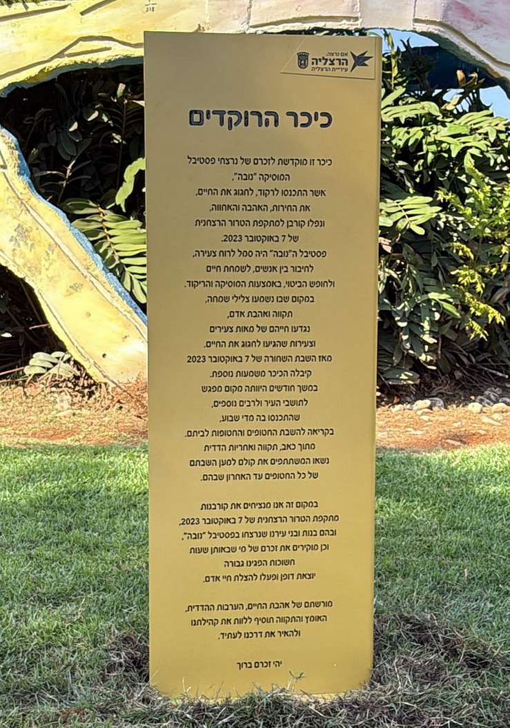 שלט ההנצחה בכיכר הרוקדים בהרצליה, המוקדש לנרצחי הנובה ומזכיר את המפגשים למען השבת החטופים. צילום: ענת לאופר
